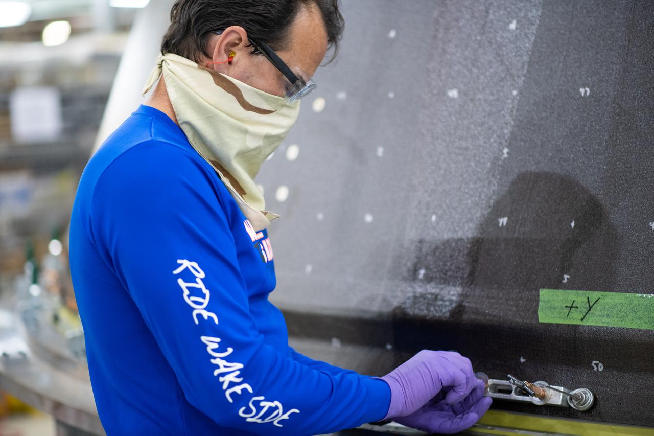 Employees wear personal protective gear at  Michoud Assembly Facility as the facility transitioned to Stage 3 of NASA’s Framework for Return To On-Site Work. Employees wear the appropriate personal protective equipment (PPE) and/or cloth face coverings as required for assigned tasks. Access to the facility is limited to authorized personnel working on mission-critical tasks that must be conducted onsite. Mission-critical tasks include slowly and methodically resuming Space Launch System (SLS) Core Stage and Orion production activities, particularly critical path deliverables to support the Artemis Program, at a pace that limits personnel and follows federal guidelines for social distancing and use of personal protective equipment such as face masks. For more information about SLS, visit nasa.gov/sls.